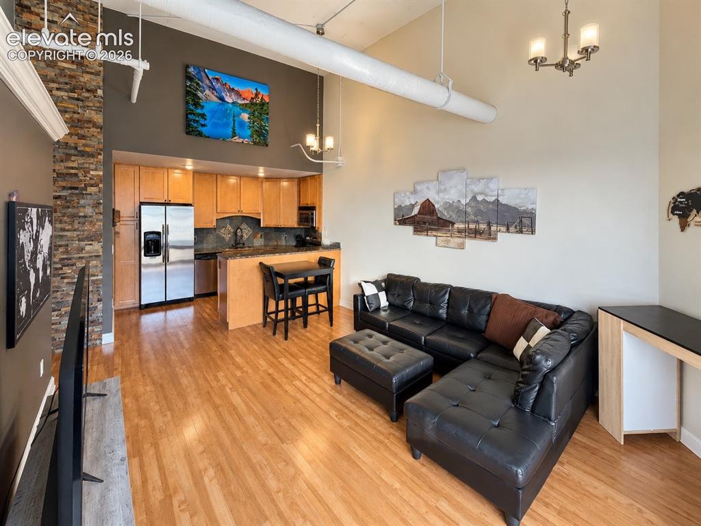 Image 11 of 35: Open-concept living space with high ceilings and wood-finish flooring