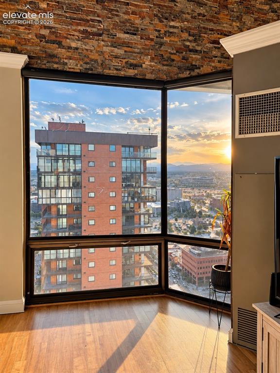Image 12 of 35: Corner window with expansive city scenery, wood-finish flooring, and a text