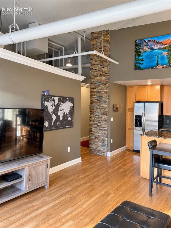 Image 14 of 35: Hardwood flooring throughout, exposed ceiling ductwork, stone-clad pillar,