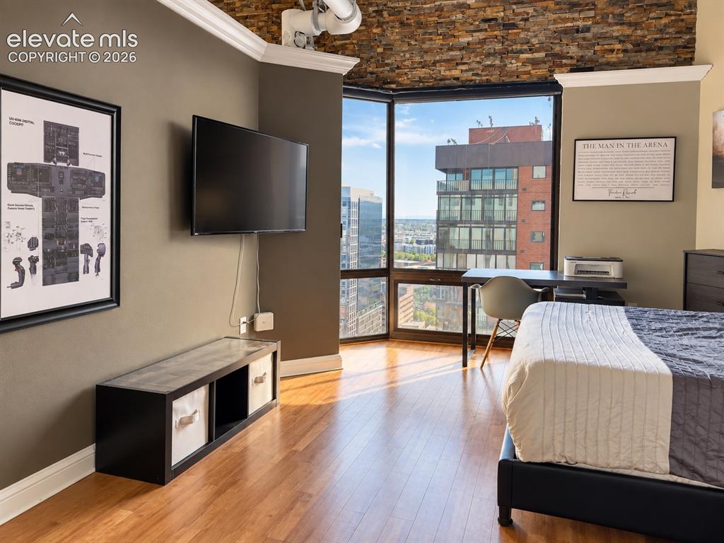 Image 16 of 35: Hardwood-finish flooring, full-height corner windows, and a stacked stone a