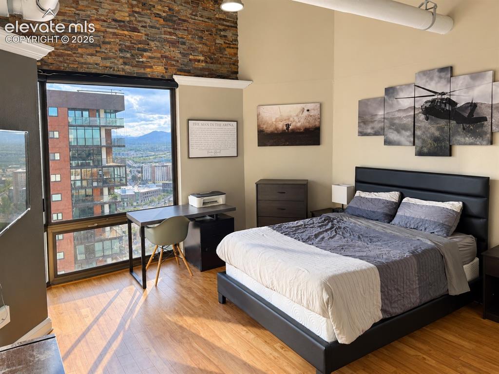 Image 17 of 35: Expansive window wall, wood-finish flooring, exposed brick accent wall, hig