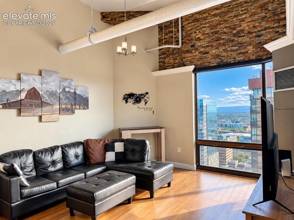Image 2 of 35: Hardwood-finish flooring, exposed brick accent wall, large picture window, 