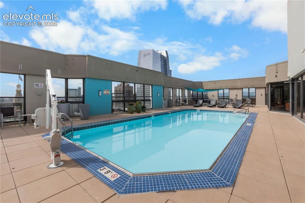 Image 27 of 35: Rooftop pool with full perimeter tiling and surrounding patio