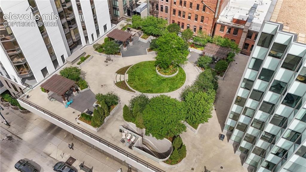 Image 29 of 35: Expansive communal rooftop featuring a central circular lawn, multiple cove