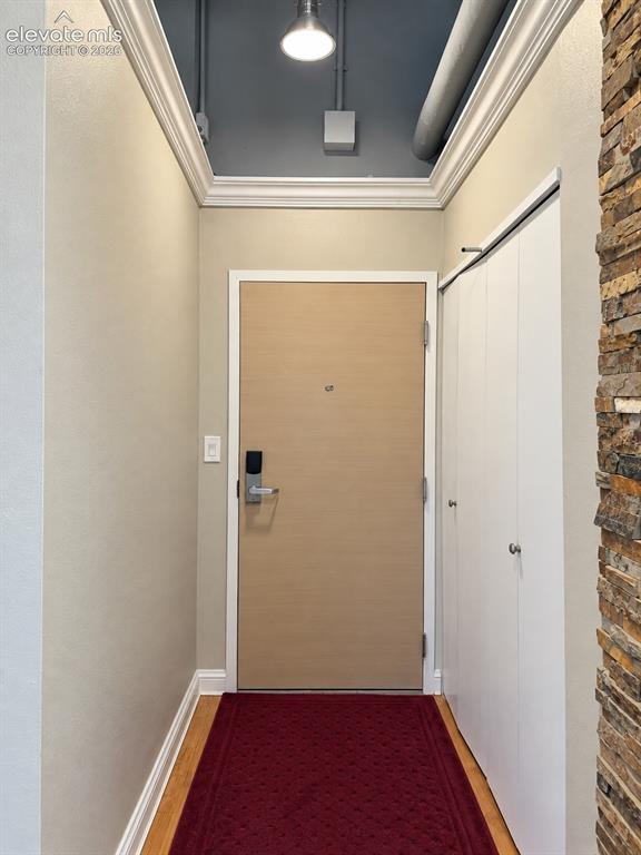 Image 4 of 35: Wood-finish flooring, accent stone wall, crown molding, exposed ceiling duc