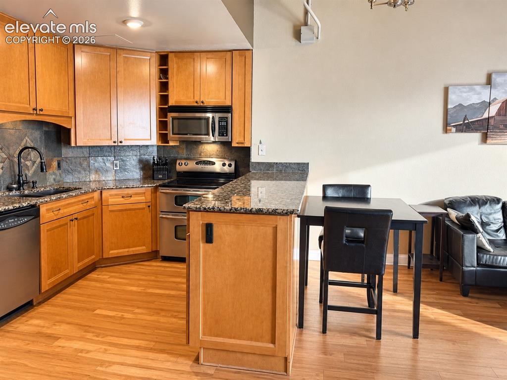 Image 8 of 35: Kitchen featuring light wood-finish cabinetry, stainless steel appliances,