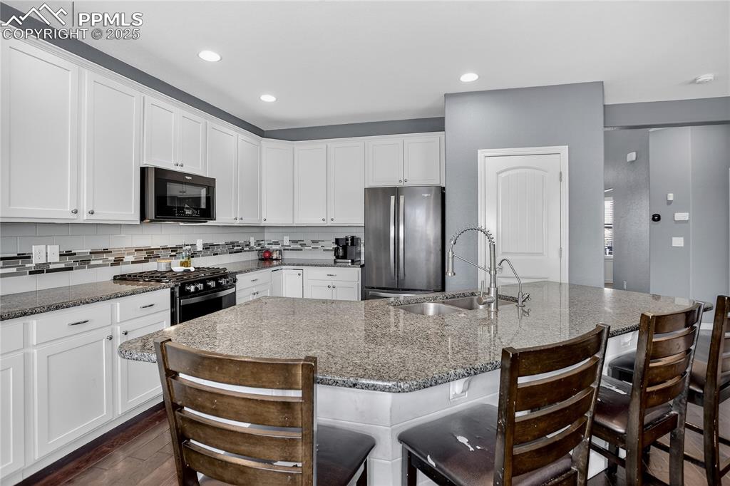 Image 5 of 26: Kitchen w/ stone counters & SS appliances