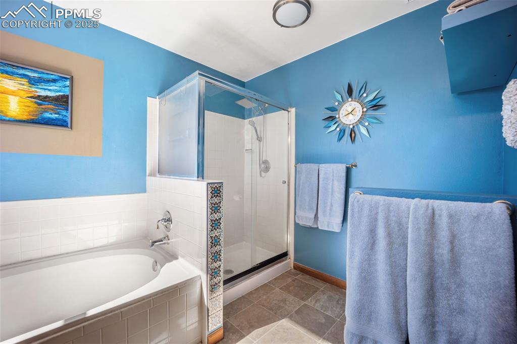Image 15 of 47: Bathroom with a shower stall and a bath