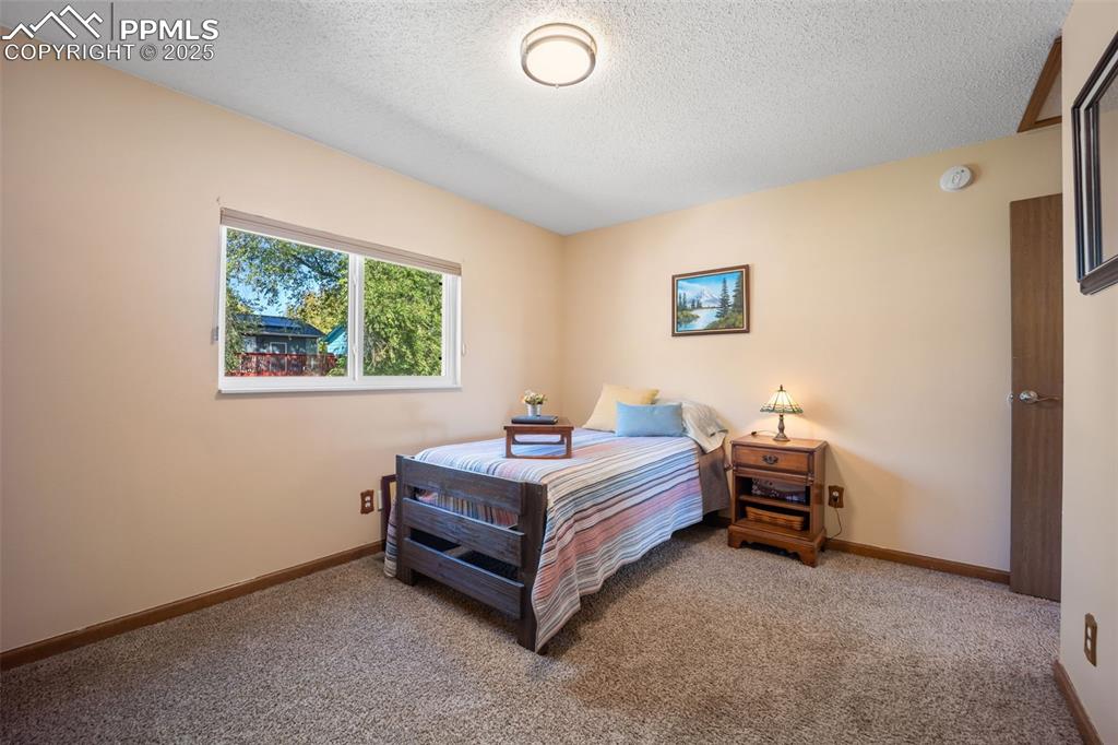 Image 18 of 47: Bedroom with a textured ceiling and carpet flooring