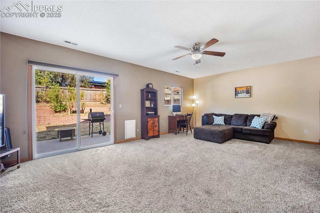 Image 23 of 47: Carpeted living area featuring baseboards and a ceiling fan
