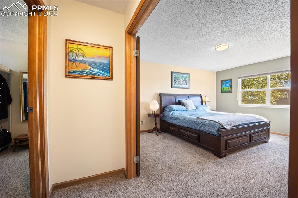Image 3 of 47: Bedroom featuring a textured ceiling and carpet