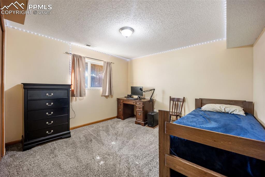 Image 30 of 47: Bedroom with carpet flooring and a textured ceiling