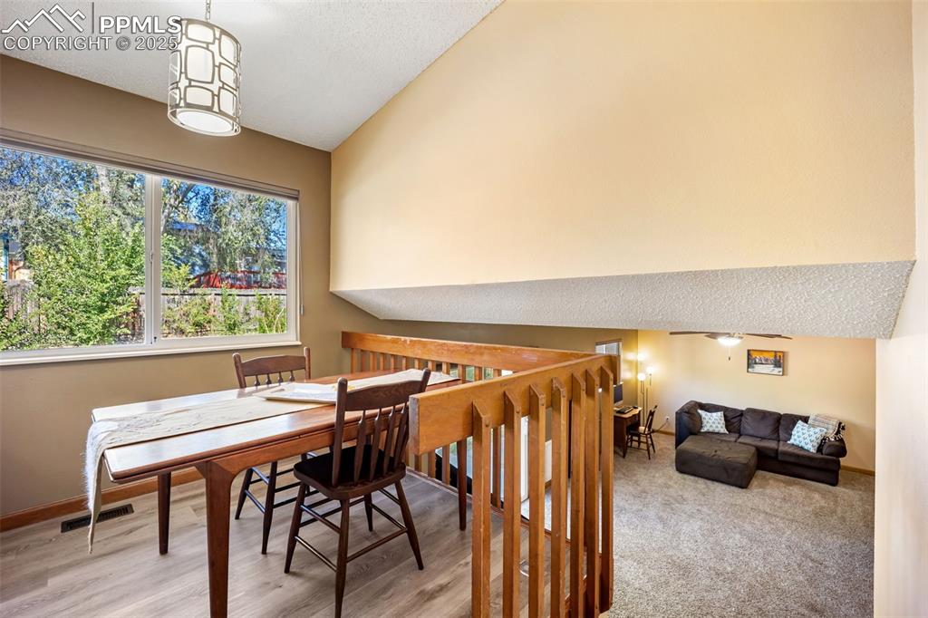 Image 9 of 47: Dining area featuring lofted ceiling, a ceiling fan, and a textured ceiling