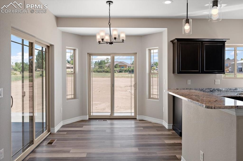 Image 12 of 40: Unfurnished dining area with dark wood-style floors, recessed lighting, and