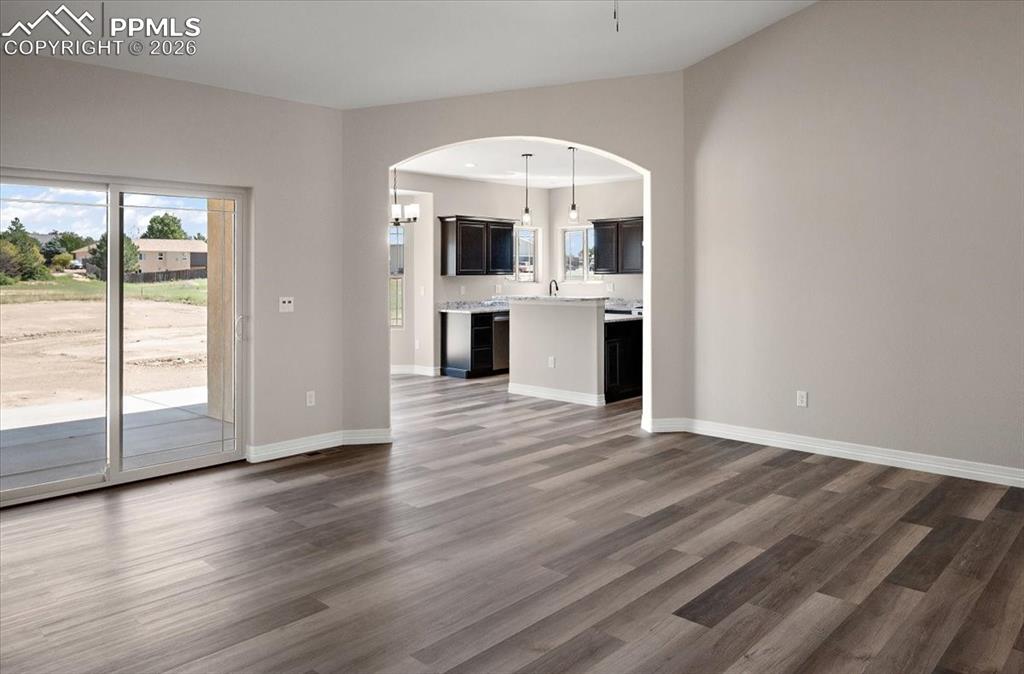 Image 13 of 40: Unfurnished living room featuring plenty of natural light, dark wood finish