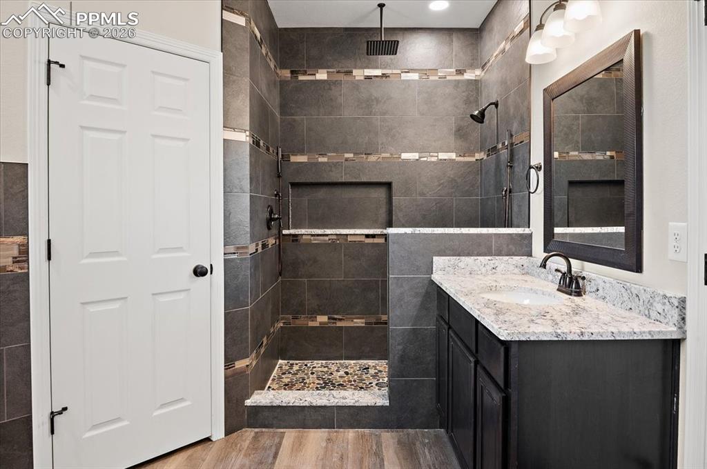 Image 19 of 40: Bathroom with vanity, a walk in shower, and light wood-style floors