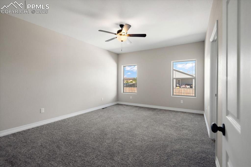 Image 24 of 40: Carpeted spare room with baseboards and a ceiling fan