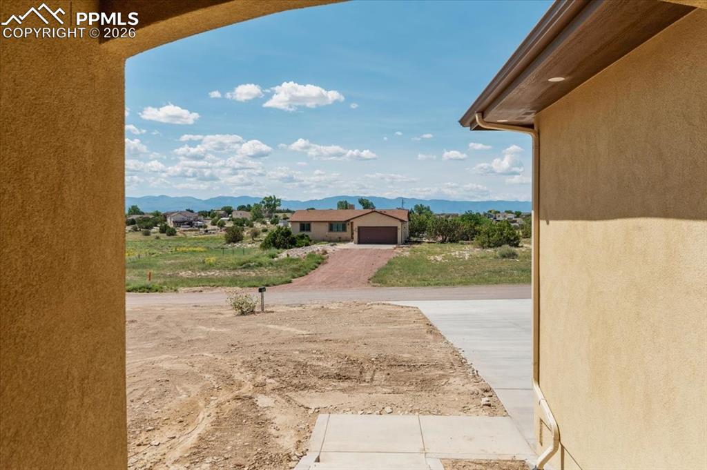 Image 31 of 40: View of yard with a mountain view and decorative driveway