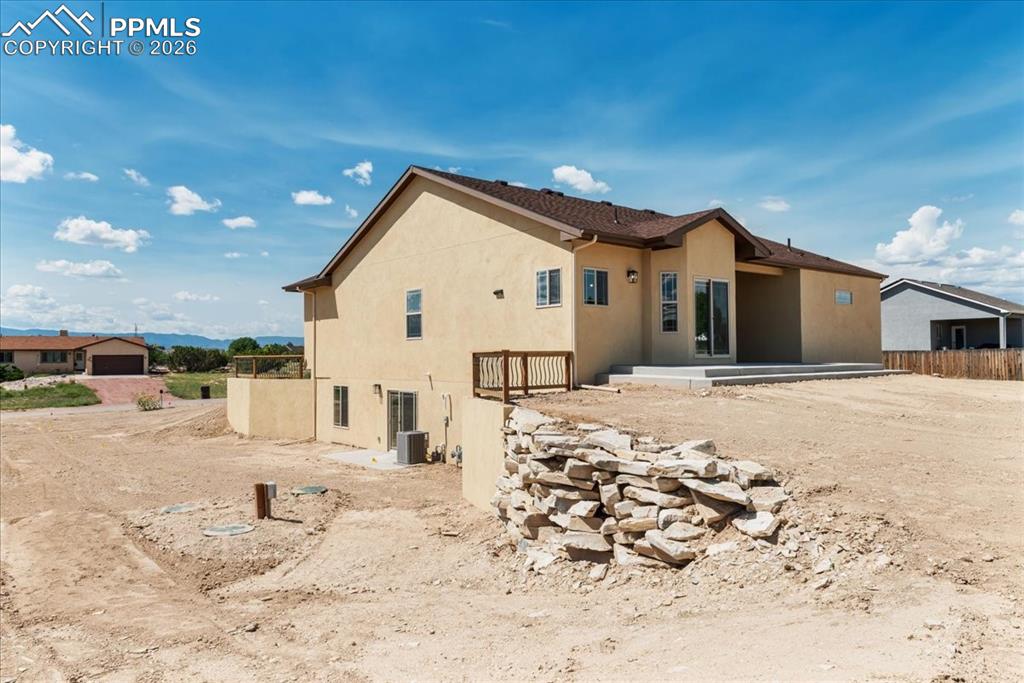 Image 37 of 40: Rear view of house featuring stucco siding and a patio area