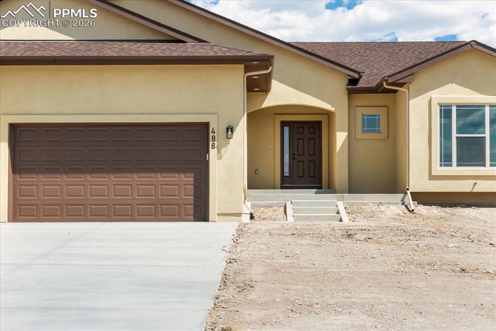 Image 39 of 40: View of front of property with roof with shingles, stucco siding, concrete 