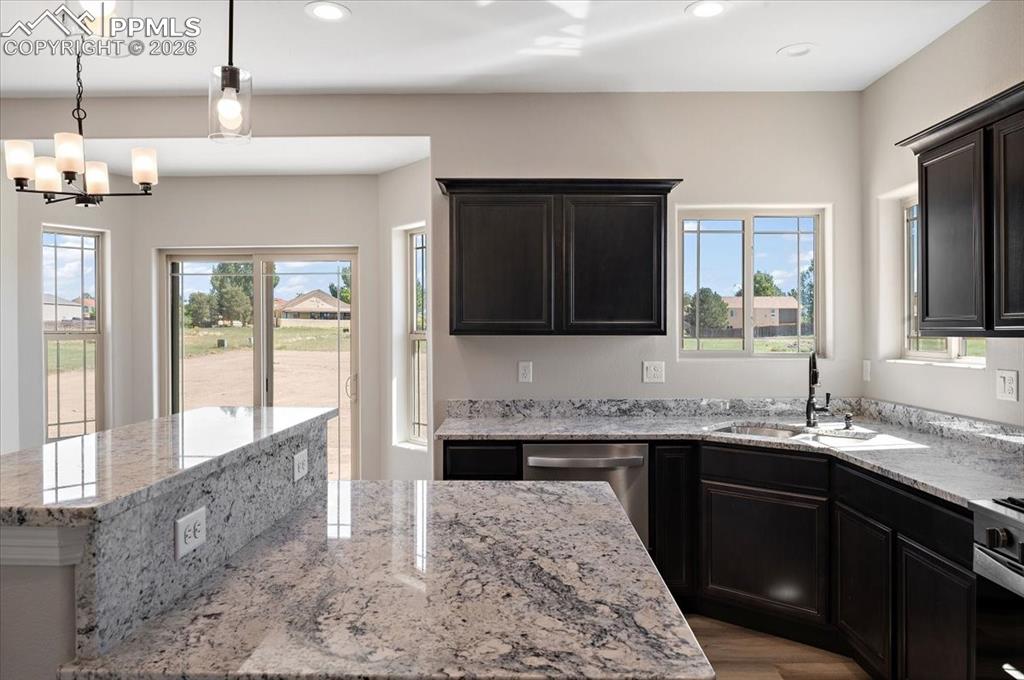 Image 9 of 40: Kitchen featuring light stone countertops, a center island, recessed lighti