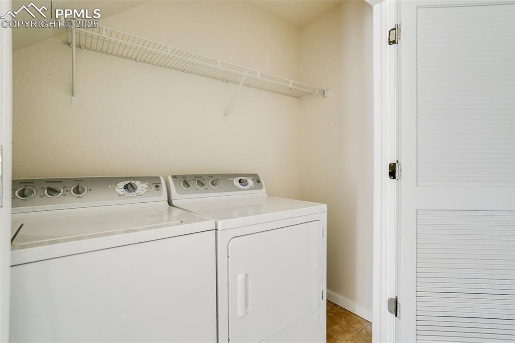 Image 14 of 28: Laundry room with light tile patterned flooring and separate washer and dry