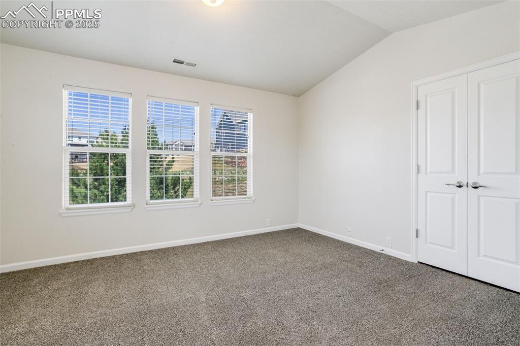 Image 15 of 28: Unfurnished bedroom featuring carpet flooring and vaulted ceiling