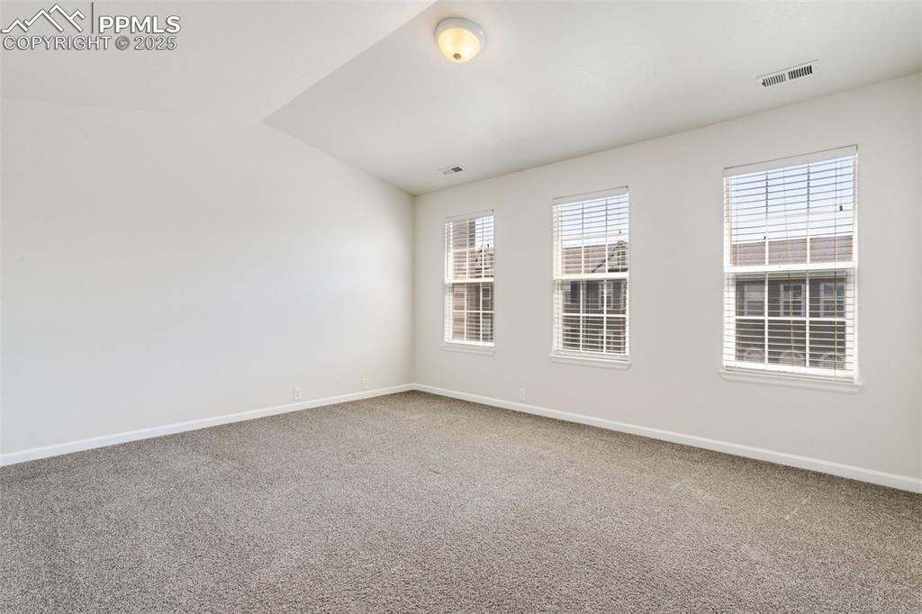 Image 19 of 28: Spare room featuring carpet floors and lofted ceiling