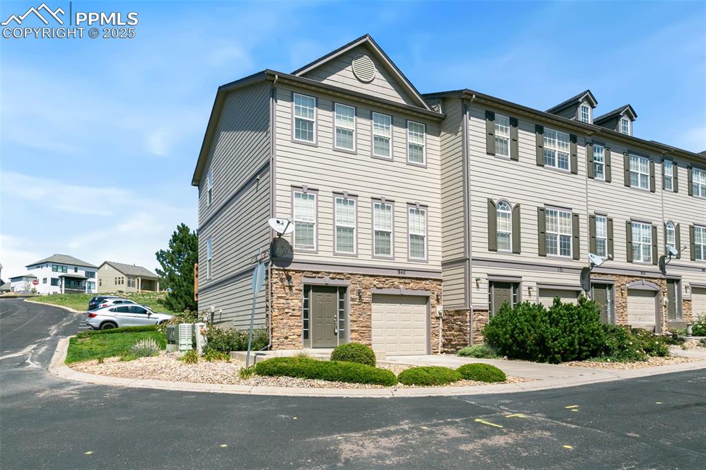 Image 2 of 28: View of front of house featuring an attached garage and stone siding
