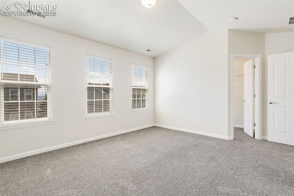 Image 20 of 28: Unfurnished room with lofted ceiling and light carpet