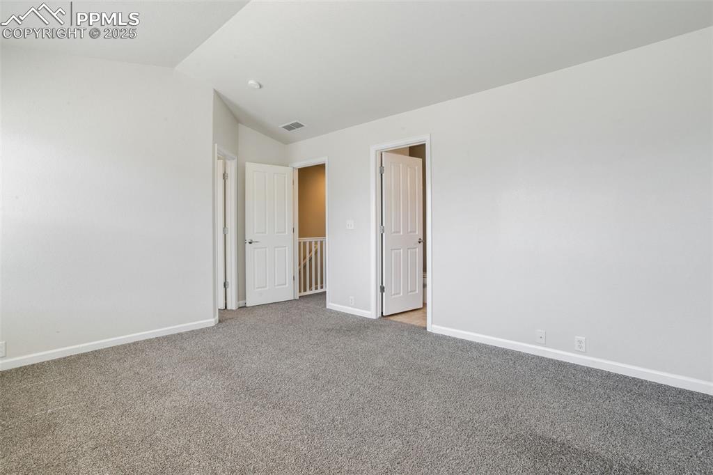 Image 21 of 28: Unfurnished bedroom featuring carpet and lofted ceiling