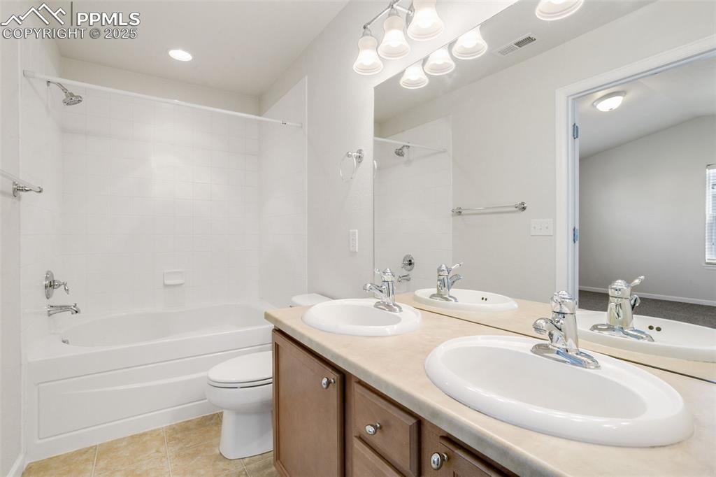 Image 24 of 28: Full bathroom featuring bathing tub / shower combination, double vanity, li