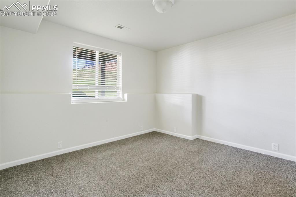 Image 25 of 28: Unfurnished room with carpet and baseboards
