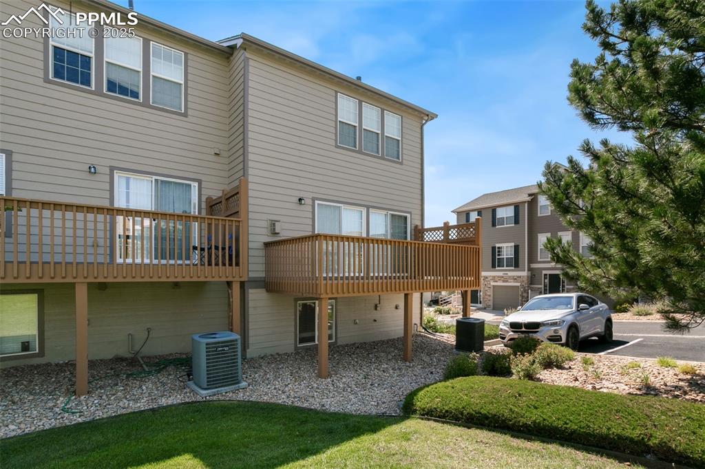 Image 28 of 28: Rear view of property with a deck and a lawn