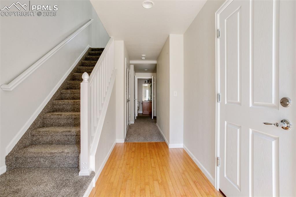 Image 3 of 28: Stairway featuring baseboards and hardwood / wood-style flooring