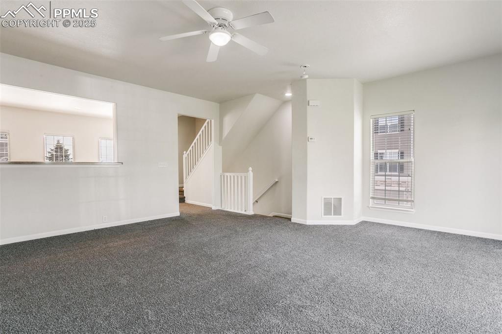 Image 6 of 28: Unfurnished living room with plenty of natural light, dark carpet, and ceil