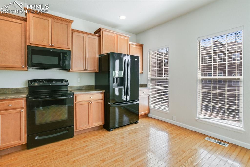 Image 9 of 28: Kitchen featuring black appliances, light wood-type flooring, and recessed 