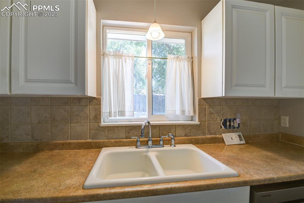 Image 13 of 23: The kitchen window overlooks a spacious backyard