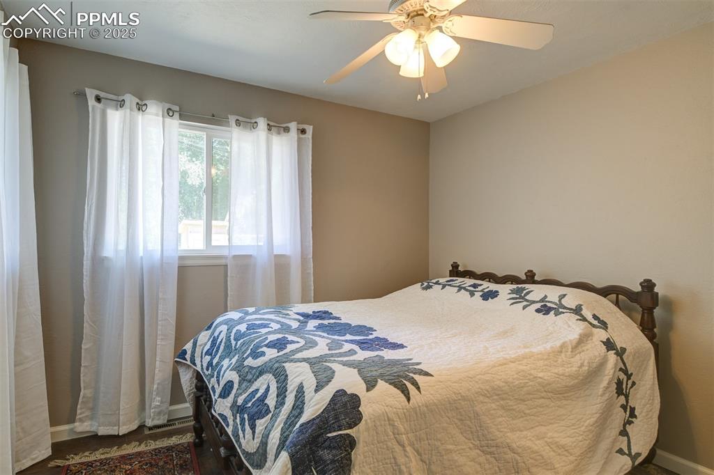 Image 17 of 23: one of two private bedrooms with hardwood floors/newer windows