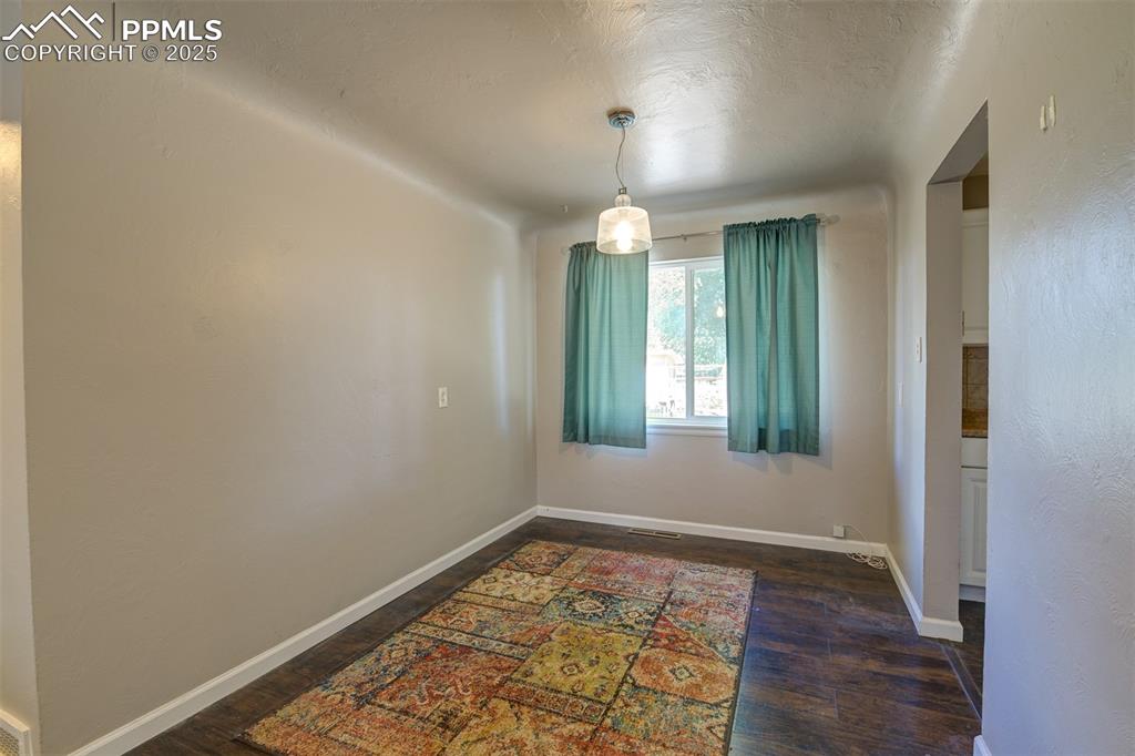 Image 8 of 23:  Cozy dining room featuring coved ceilings, wood floors