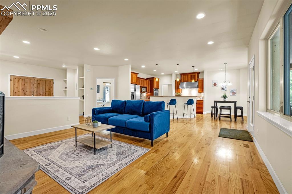 Image 11 of 41: Living room with light wood-style floors, recessed lighting, and baseboards