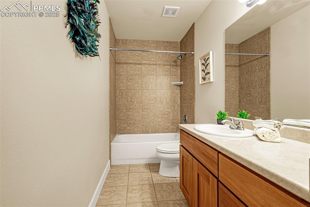 Image 26 of 41: Full bath featuring vanity, toilet, tile patterned floors, shower / washtub