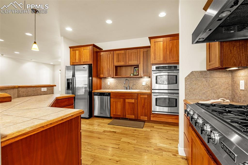 Image 7 of 41: Kitchen with ventilation hood, appliances with stainless steel finishes, a 