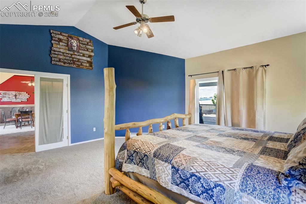 Image 14 of 50: Bedroom featuring access to exterior, carpet floors, vaulted ceiling, and a