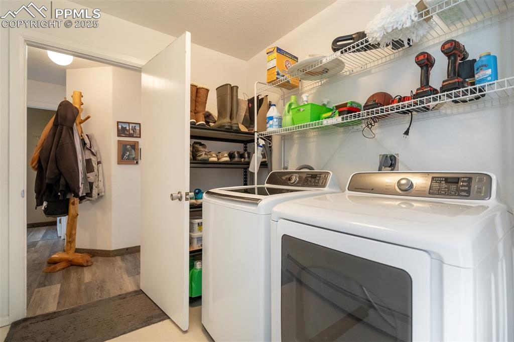 Image 29 of 50: Laundry area with independent washer and dryer and light wood finished floo