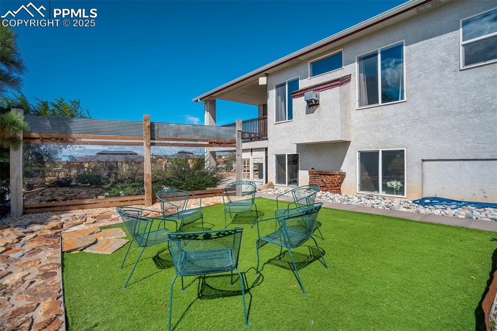 Image 36 of 50: View of green lawn featuring a balcony and a patio