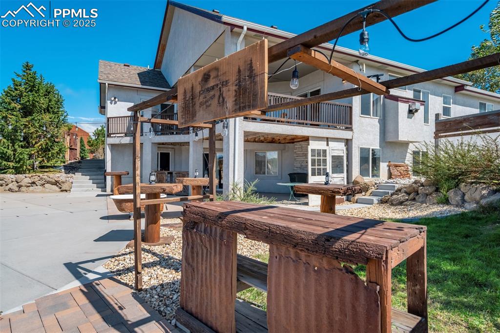 Image 41 of 50: Rear view of property with a patio area, a balcony, stairs, stucco siding,