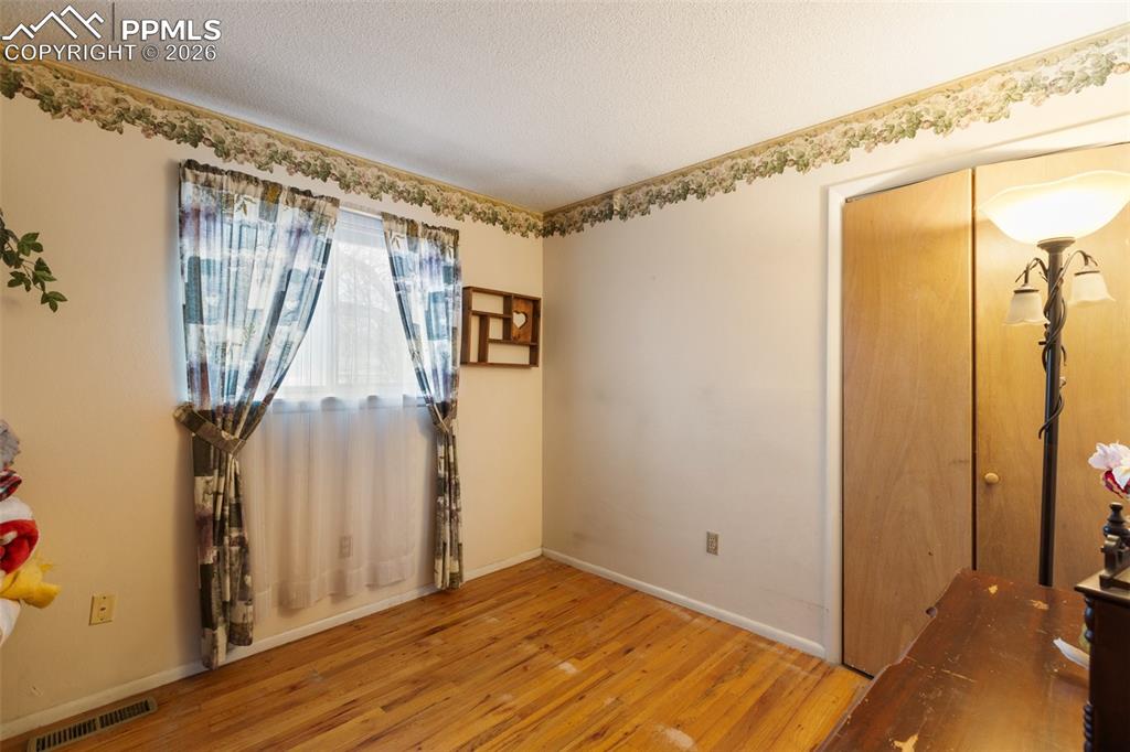 Image 22 of 34: One of 3 bedrooms on the upper level - features wood flooring