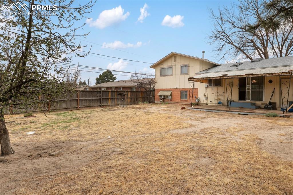 Image 4 of 34: Large fenced yard and covered concrete patio