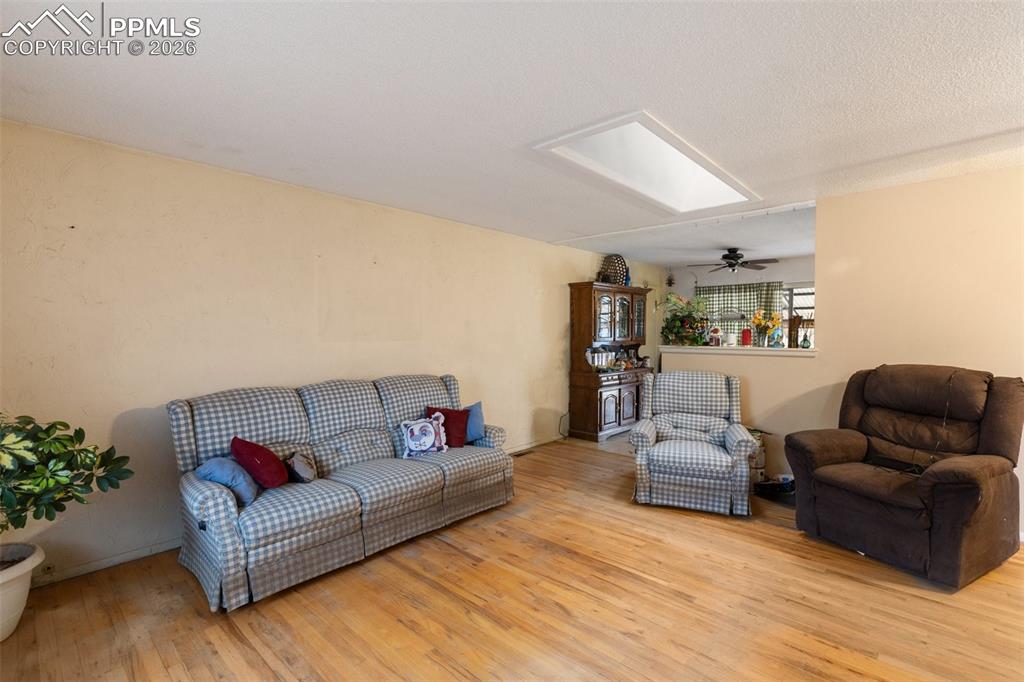 Image 6 of 34: Main level features this living room with a skylight and wood flooring